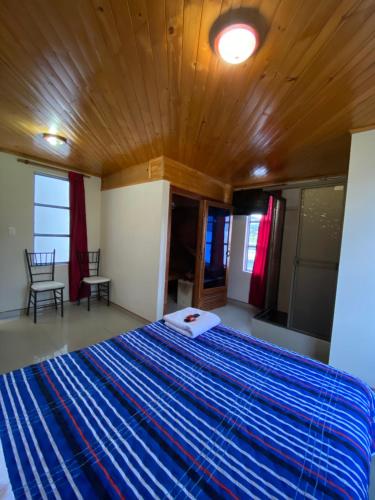 a bedroom with a large bed with a wooden ceiling at Hotel Las Palmeras Gachancipa in Gachancipá