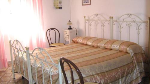 a white bed in a bedroom with a window at Albergo Europa in Marina di Mancaversa