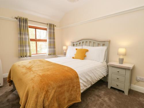 a bedroom with a bed and a window at Laithe Cottage in Ulverston