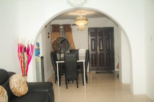 a dining room with a table and black chairs at Home Away from Home in Gowon Estate, Ipaja in Lagos