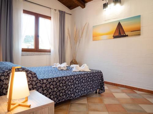 a bedroom with a bed and a sailboat on the wall at Il Veliero Tanca Piras in Nebida