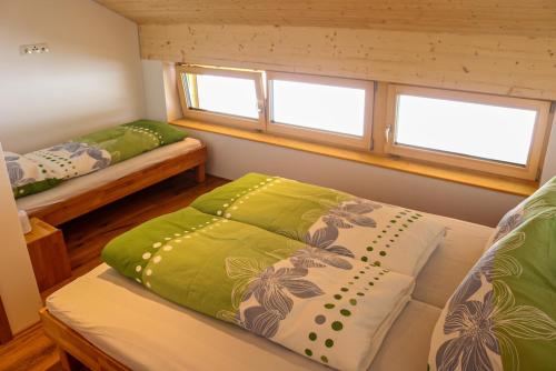 um pequeno quarto com duas camas e duas janelas em Ferienwohnung Berchtold em Schnepfau