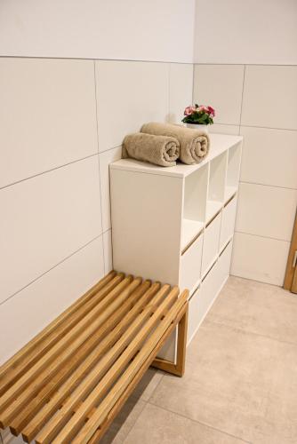 a bench in a bathroom with towels on a shelf at Ferienwohnung Berchtold in Schnepfau