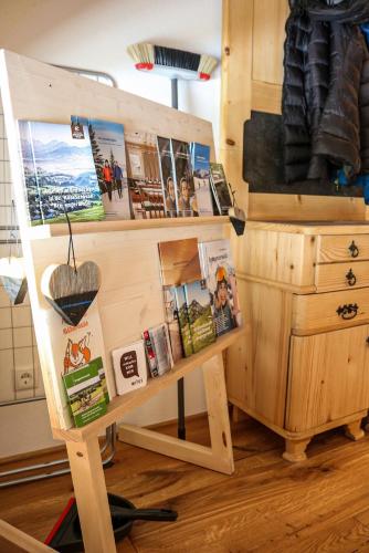 a wooden stand with a book shelf and a desk at Ferienwohnung Berchtold in Schnepfau