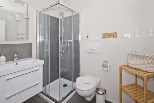 ein weißes Badezimmer mit Dusche und Toilette in der Unterkunft zentrale FeWo mit Balkon, gratis Nutzung vom AHOI Erlebnisbad und Sauna in Sellin - Villa Buskam FeWo 22 in Göhren