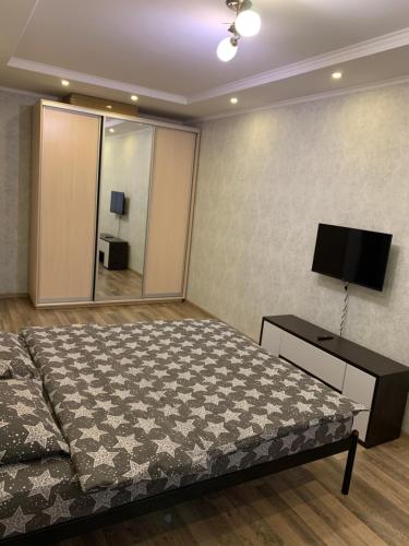 una camera con letto e TV a schermo piatto di 028 Апартаменты в ЖК "Софиевская Слободка" a Vyšneve