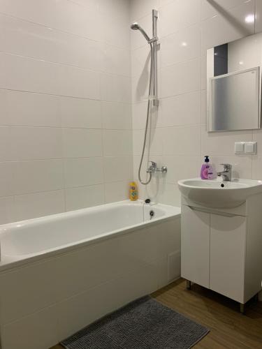 un bagno bianco con vasca e lavandino di 028 Апартаменты в ЖК "Софиевская Слободка" a Vyšneve