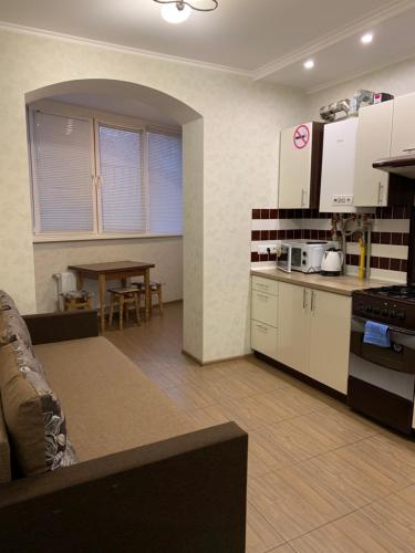 una cucina con armadi bianchi e un tavolo in una stanza di 028 Апартаменты в ЖК "Софиевская Слободка" a Vyšneve