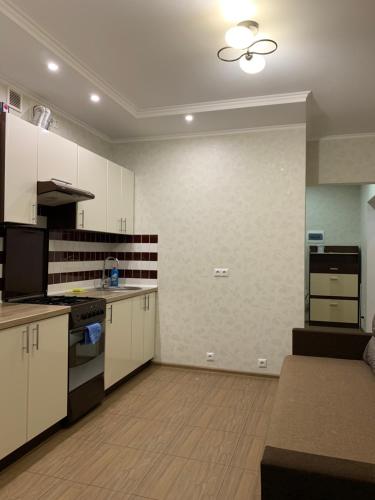 una cucina con armadi bianchi e piano cottura di 028 Апартаменты в ЖК "Софиевская Слободка" a Vyšneve