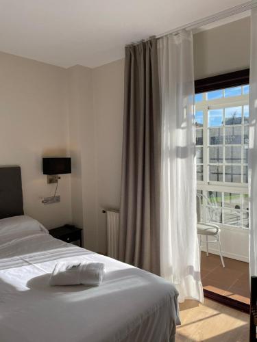 a bedroom with a bed and a large window at Hotel San Marcus in Porta