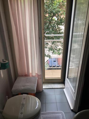 uma casa de banho com um WC ao lado de uma janela em Piccolo hotel le Palme em San Bartolomeo al Mare