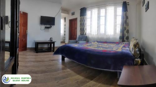 a bedroom with a bed and a tv in it at MANNA INSPIRA in Shillong