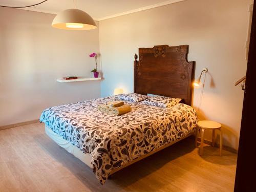 um quarto com uma cama e uma cabeceira em madeira em Happy Ria House em Chousa Velha