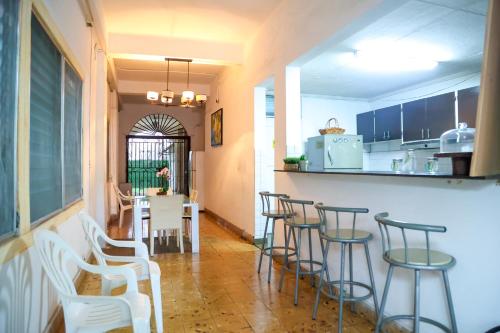 a kitchen with a bar with stools and a table at Hostal Villa Grande in Panama City