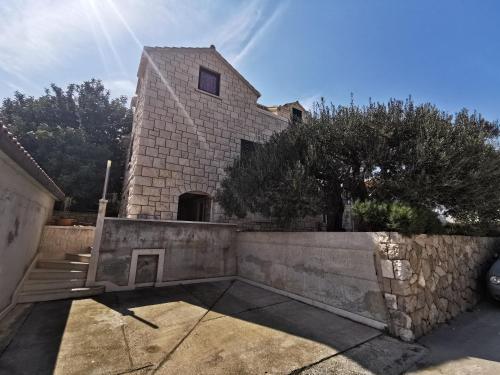 una casa con una pared de piedra y escaleras en Villa Ela, en Postira