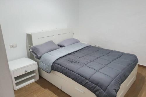 Schlafzimmer mit einem Bett mit blauer Decke in der Unterkunft Sueño Playitas in Las Playitas