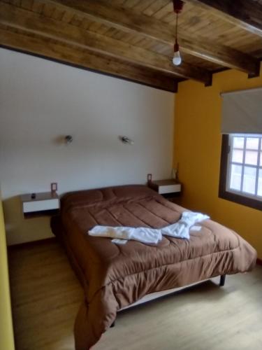 een slaapkamer met een bed met twee handdoeken erop bij MALARGUE STYLE,A 100 Mtrs DEL CENTRO,MUY UBICADO in Malargüe