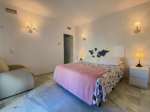 1 dormitorio con 1 cama, 1 silla y lámparas en ALOJAMIENTO EN LA CARIHUELA-COSTA DEL SOL, en Torremolinos