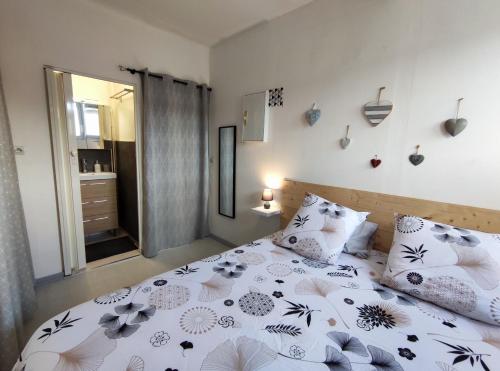 a bedroom with a bed with a floral bedspread and pillows at Joli petit T2 terrasse proche du phare in Calais