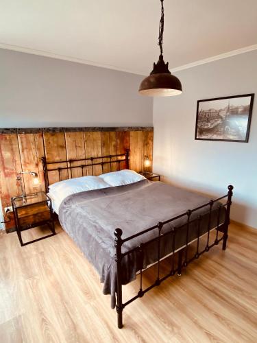 a bedroom with a large bed with a wooden headboard at COAST HOUSE River Docks in Bremerhaven
