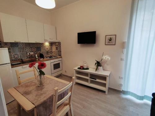 a kitchen with a table with a vase of flowers on it at Botteghelle Home in Casalnuovo di Napoli