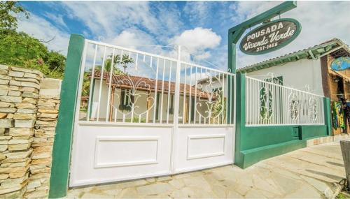 a white and green gate in front of a building at Pousada Vivenda Verde in Pirenópolis