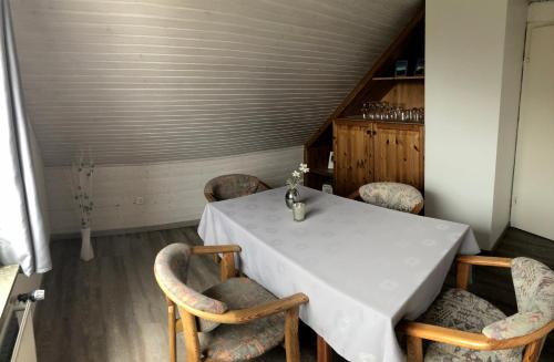 a dining room with a white table and chairs at Haus Magnussen in Dagebüll