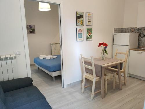 a kitchen and dining room with a table and a refrigerator at Botteghelle Home in Casalnuovo di Napoli