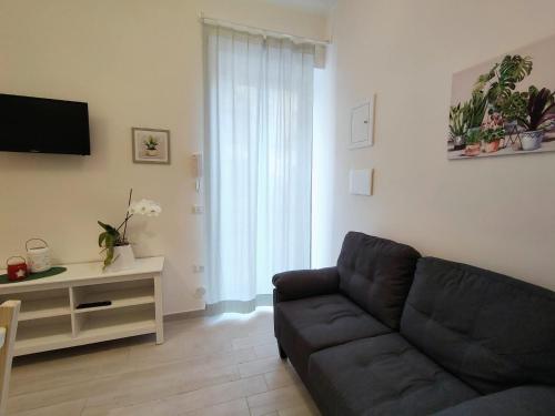 a living room with a couch and a tv at Botteghelle Home in Casalnuovo di Napoli