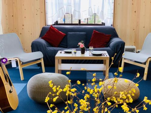 a living room with a blue couch and a table at Sunhouse - Vacation STAY 28595v in Yachimata