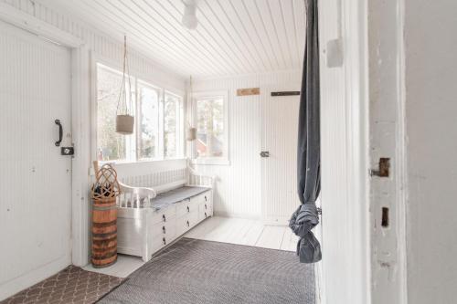 ein weißes Badezimmer mit Badewanne und Fenster in der Unterkunft Beautifully renovated lakeside red cottage in Salo