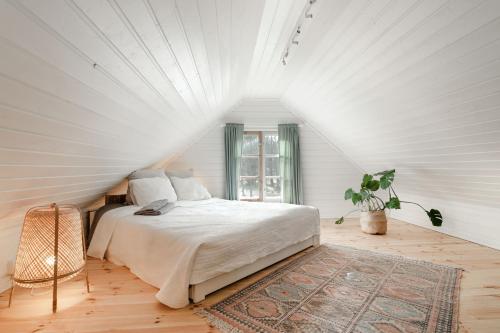Habitación blanca con cama y ventana en Beautifully renovated lakeside red cottage, en Salo