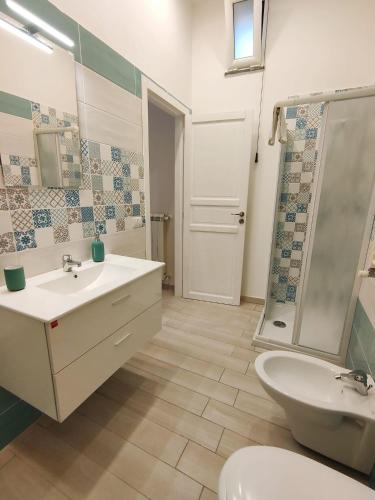 a bathroom with a sink and a toilet and a shower at Botteghelle Home in Casalnuovo di Napoli
