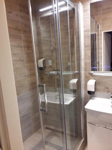 a glass shower in a bathroom with a sink at Penzion Vulture Ostrava in Ostrava