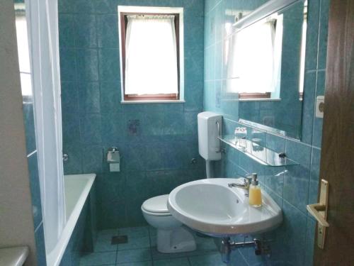ポスティラにあるVilla Elaの洗面台とトイレのある青いバスルーム