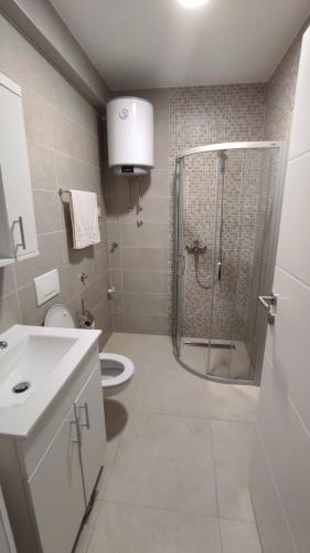 a bathroom with a shower and a toilet and a sink at M&I Apartment in Doboj