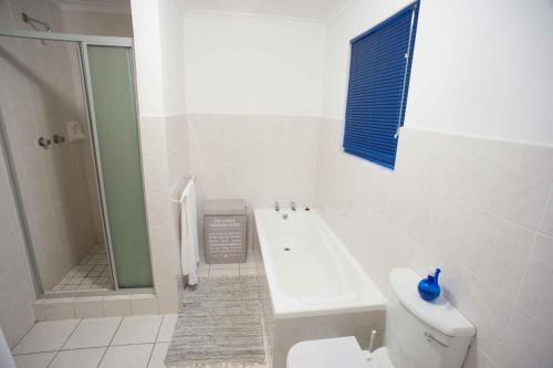 ein Bad mit einer Badewanne, einem WC und einer Dusche in der Unterkunft 20 Cayman Beach, Gordon's Bay in Gordonʼs Bay