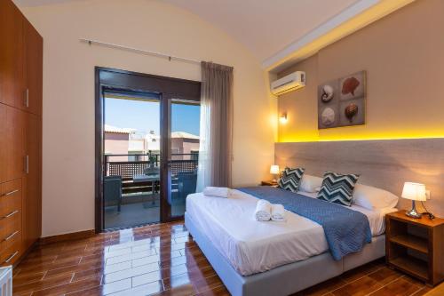 a bedroom with two beds and a balcony at Villa Dafni in Pangalochori