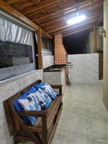 a room with a bench in a kitchen with a stove at Chale do Caruso in Mairinque