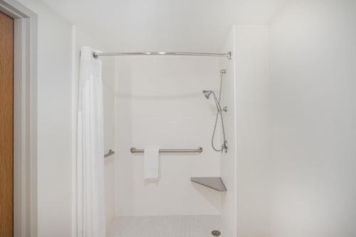 een witte badkamer met een douche en een wastafel bij Holiday Inn Express Hotel & Suites Louisville East, an IHG Hotel in Louisville
