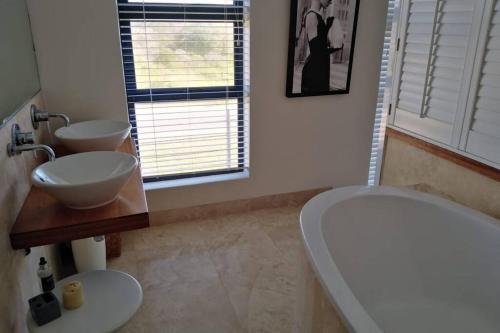 a bathroom with a tub and a toilet and a sink at Beach House in Pearly Beach