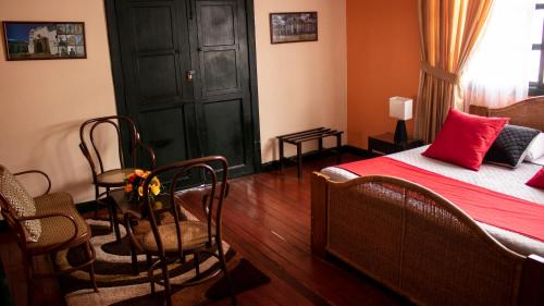 a bedroom with a bed and a table and chairs at Hotel La Herreria Colonial in Popayan