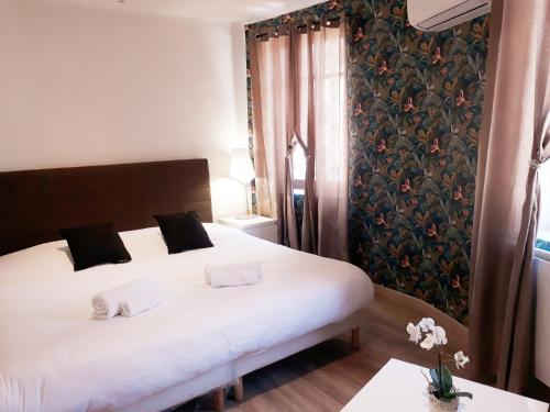 Un dormitorio con una gran cama blanca y una ventana. en Hotel renaissance martigues, en Martigues