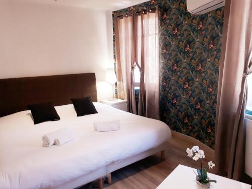a bedroom with a large white bed and a window at Hotel renaissance martigues in Martigues