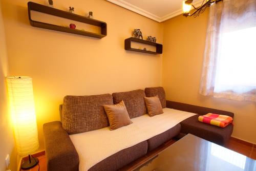 ein Wohnzimmer mit einer Couch und einem Fenster in der Unterkunft Cuencaloft Relax en familia con barbacoa in Chillarón de Cuenca