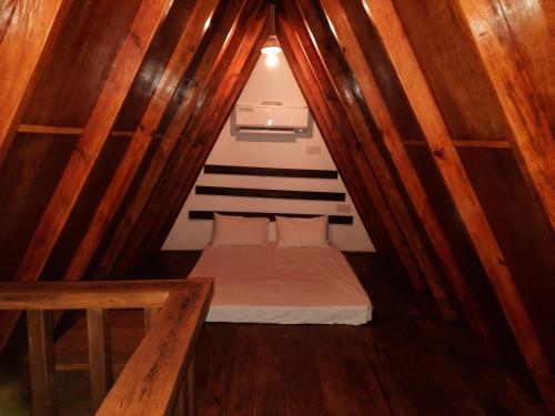 a small bed in a small room with wooden walls at The Otunna Guest House Sigiriya in Sigiriya