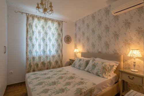 um quarto com uma cama e uma janela com papel de parede floral em MARIOS VILLAS em Poros