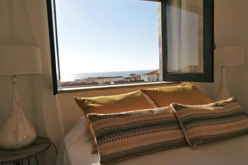 a bed with two pillows in front of a window at Beachy 2Bdrm in Santa Cruz w/ stunning Ocean View! in Santa Cruz