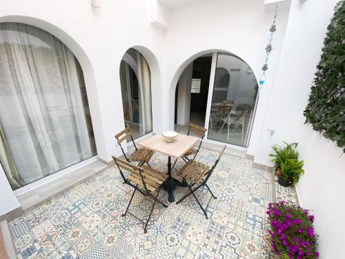 een patio met een tafel en stoelen op een tegelvloer bij Casa Kalameta in Estepona