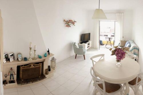 a white living room with a table and a fireplace at Beachy 2Bdrm in Santa Cruz w/ stunning Ocean View! in Santa Cruz